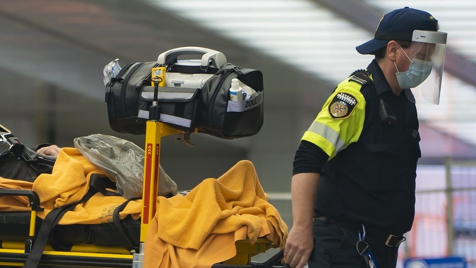 Un ambulancier transporte un patient sur une civière à l'Hôpital Mont Sinaï de Toronto.