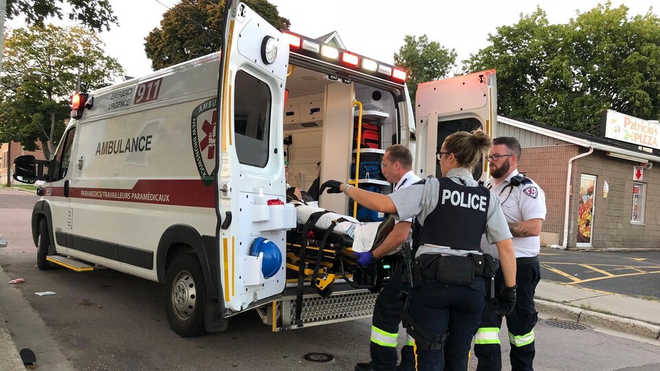 Des paramédicaux installent un blessé dans une ambulance.