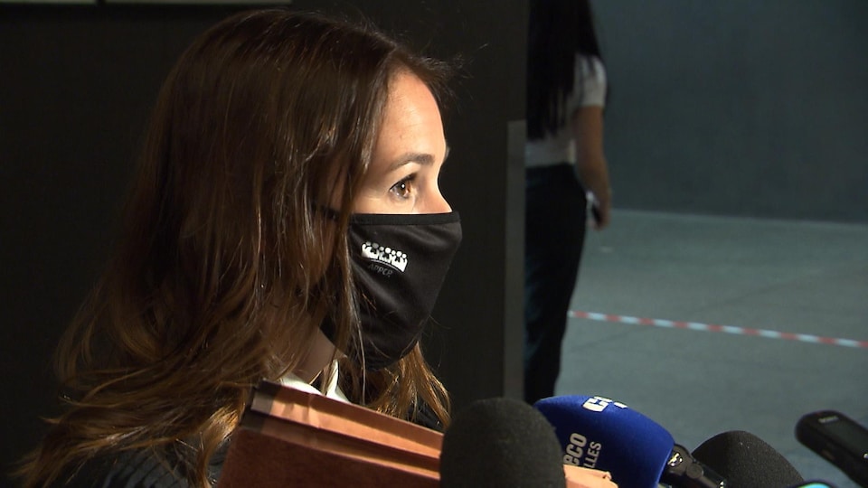 Me Rivard, masquée et portant une toge, répond aux questions des journalistes lors d'une mêlée de presse dans le corridor du palais de justice de Montréal.