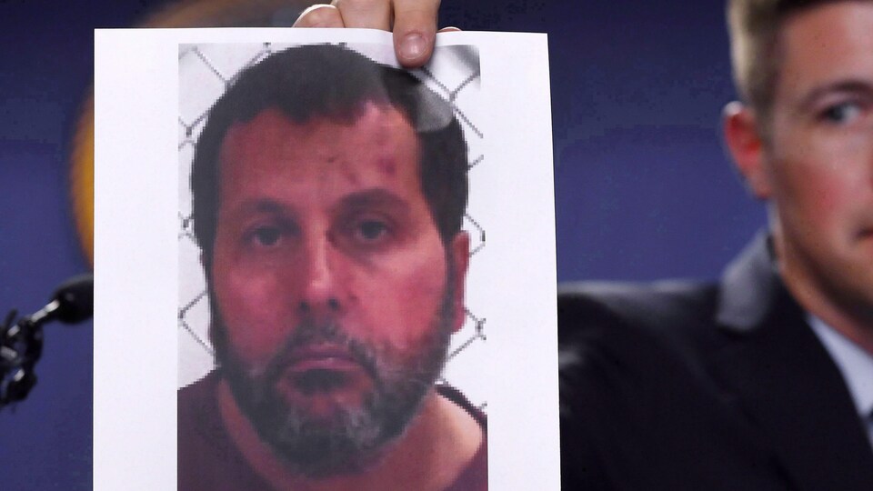 Photo d'Amor Ftouhi présentée par un homme en arrière-plan.
