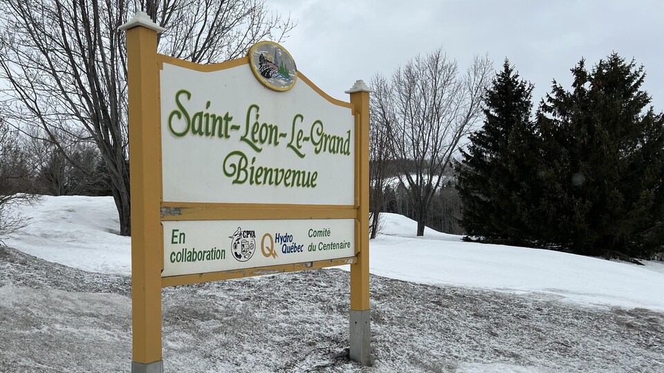 Un grand panneau en bois indique le nom de la ville.