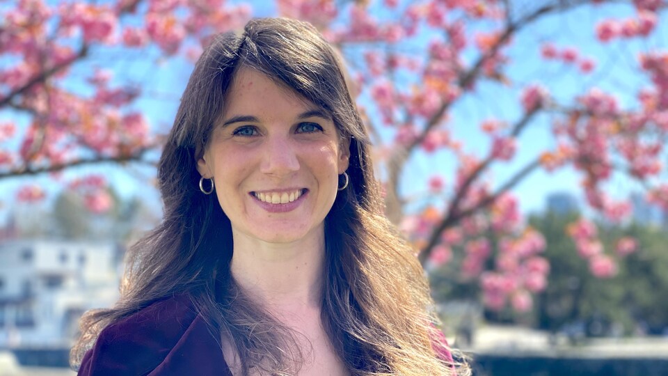 Portrait d'Anaïs Pellin devant des cerisiers en fleurs.