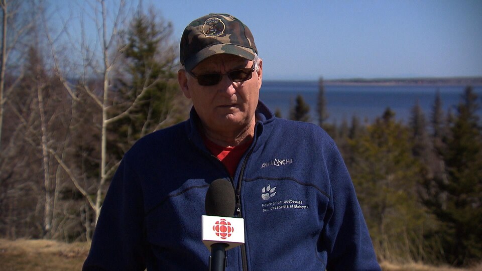 André Boulianne en entrevue sur une colline devant un lac au printemps.