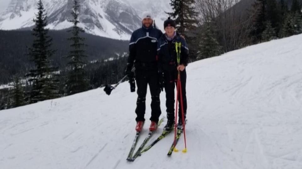 Le skieur André Bourque et sa fille sur une montagne enneigée. 
