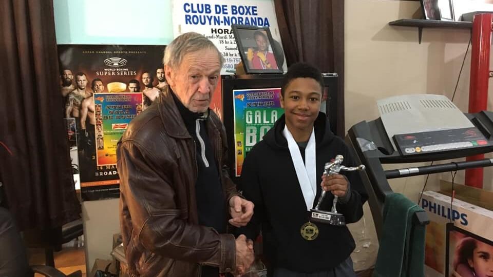 André Pellan et Gabriel Aly-Ndiaye au Club de boxe de Rouyn-Noranda. Gabriel Aly-Ndiaye tient un trophée de boxe dans une main.