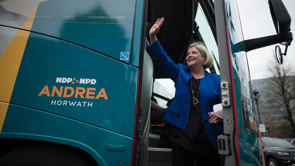 La chef Andrea Horwath salue les journalistes en montant dans son autocar de campagne.