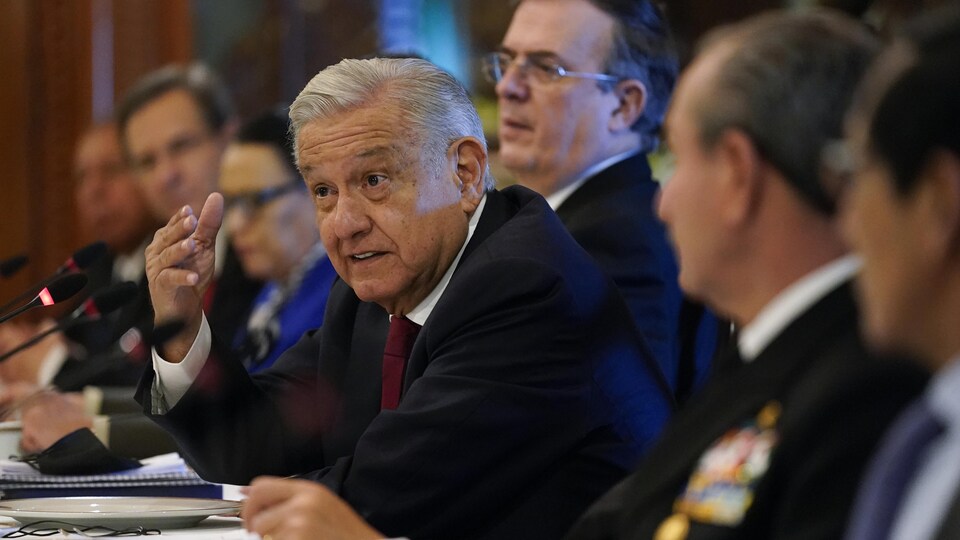 Andres Manuel Lopez Obrador prend la parole. Il est assis à une table avec une dizaine de personnes.