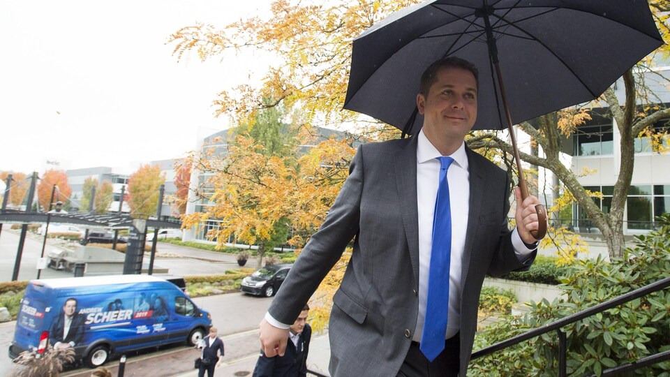 Le chef conservateur monte un escalier en tenant un parapluie.