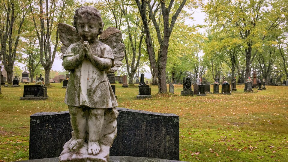 La statue d'un ange sur une pierre tombale.