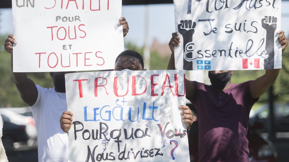 Une manifestation avec des pancartes brandies en soutien aux demandeurs d'asile.