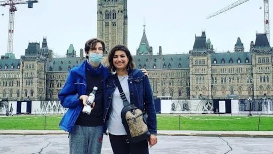 Une photo d'Angela et son fils, debout devant le Parlement à Ottawa.