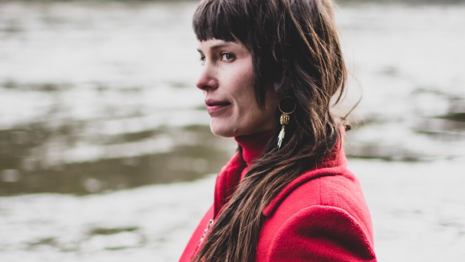 Une femme seule sur le bord d'un cours d'eau.