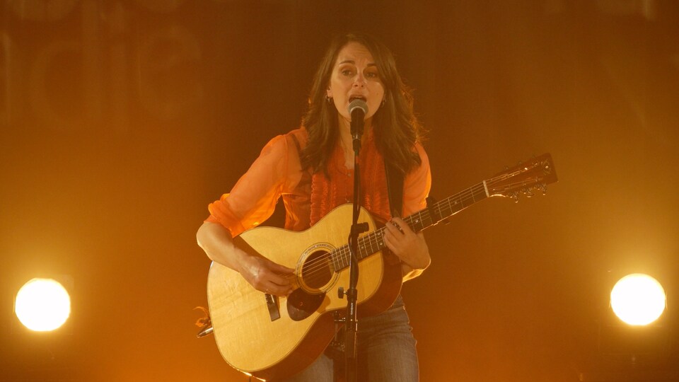 Anique Granger sur scène, noyée dans un éclairage orange.