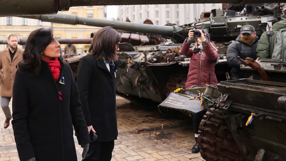     La ministra de Defensa canadiense, Anita Anand, observa los tanques blindados.