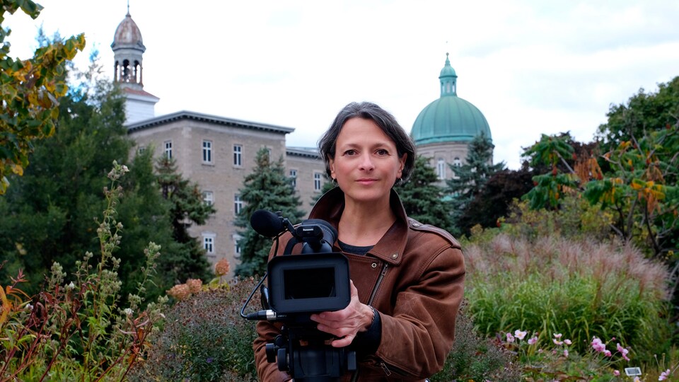 La réalisatrice Annabel Loyola tient une caméra avec en arrière-plan l'Hôtel-Dieu.