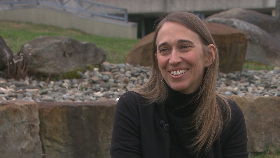 Anne Brault-Labbé est assise à l'extérieur devant l'Université de Sherbrooke.