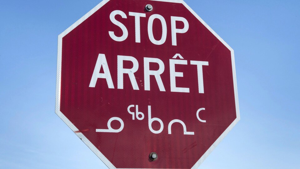 Un panneau de signalisation en anglais, français et inuit situé à Iqaluit, au Nunavut. 
