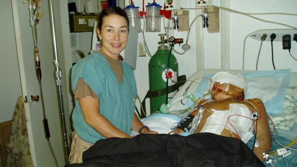 Annie Tétrault au chevet d'un blessé à l'hôpital.