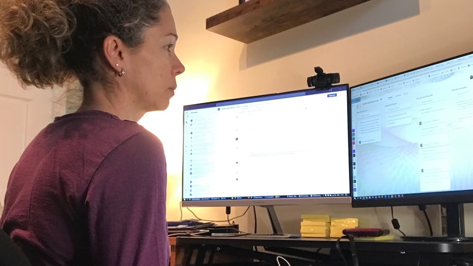 Une femme assise devant son ordinateur.