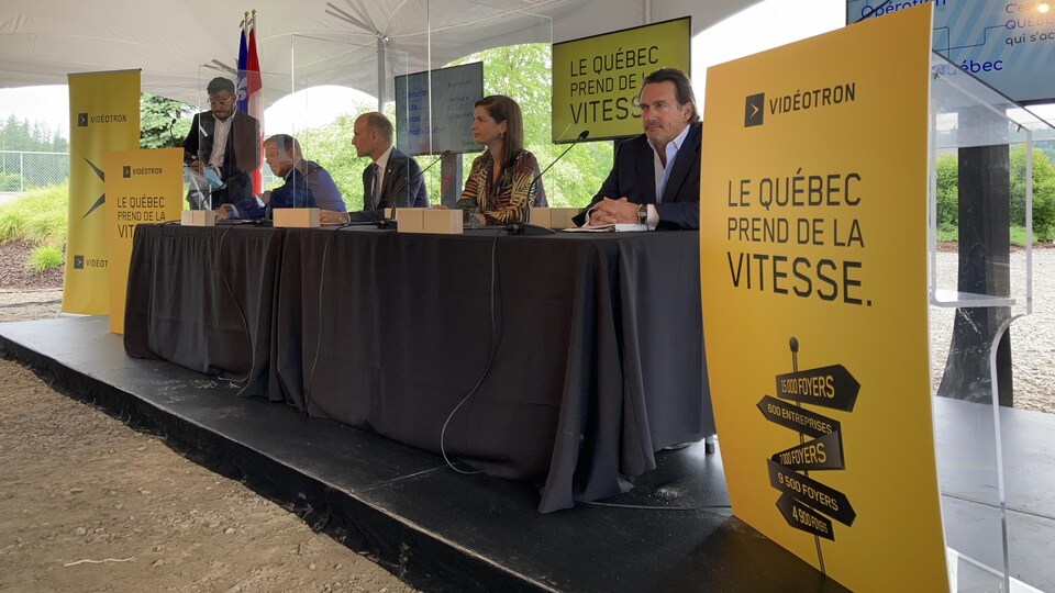 Les députés et Pierre Karl Péladeau assis à une table lors de l'annonce.