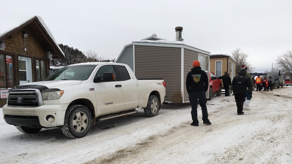 Des pêcheurs patientent en attendant de pouvoir installer leurs cabanes sur la glace.