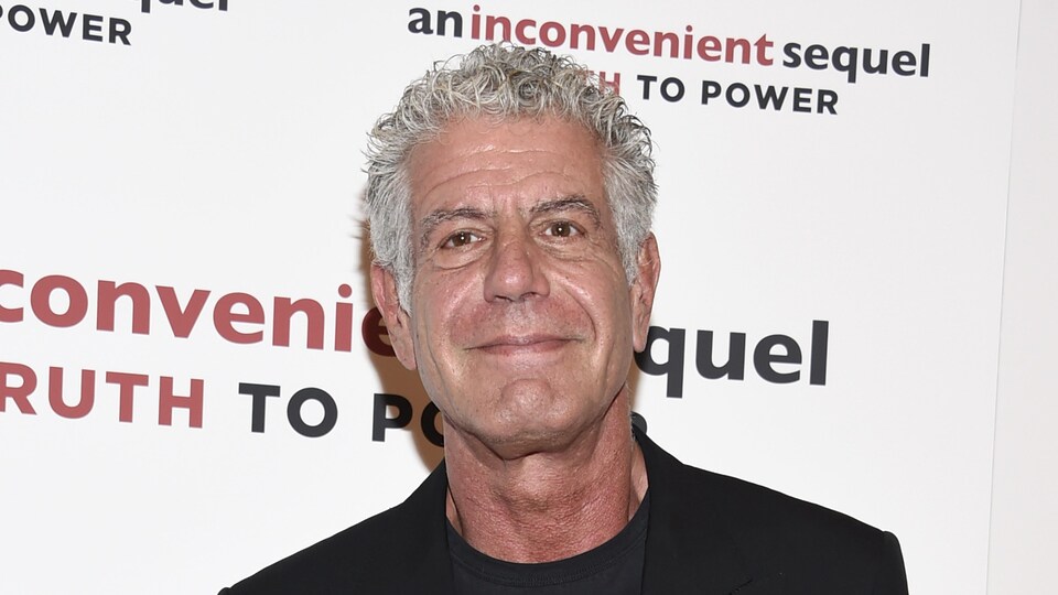 Anthony Bourdain devant un mur promotionnel du film An Inconvenient Sequel : Truth To Power.