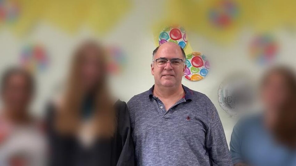 Anthony Ross dans une photo avec d'autres personnes dont l'image a été brouillée pour protéger leur identité.