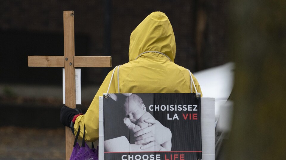 Un manifestant anti-avortement assis devant une clinique à Montréal.