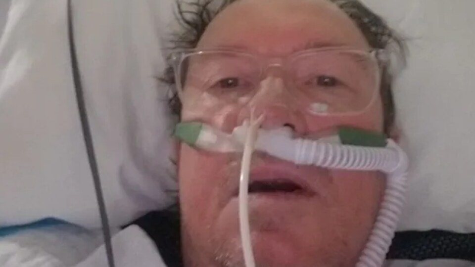 Selfie de Bryan Baraniski qui a des tubes dans le nez pour l'aider à respirer alors qu'il est atteint de la COVID-19.
