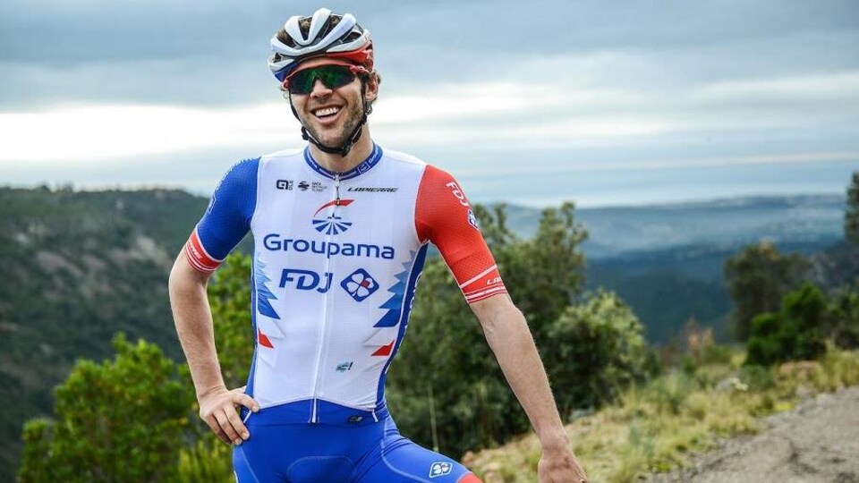 Antoine Duchesne chevauche son vélo. Il est souriant.