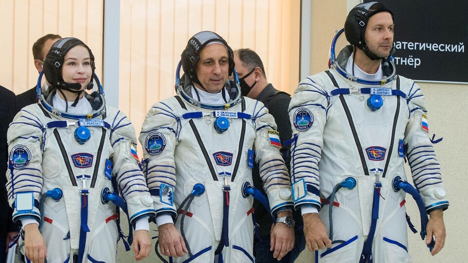 Les trois portent leur combinaison d'astronaute et se tiennent en rangée. 