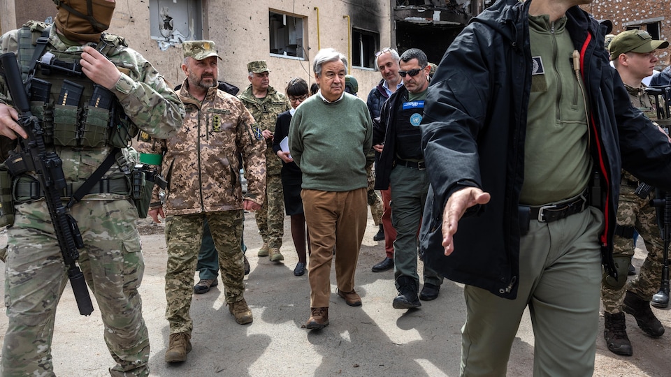 Antonio Guterres marche dans Kiev entouré de soldats. 
