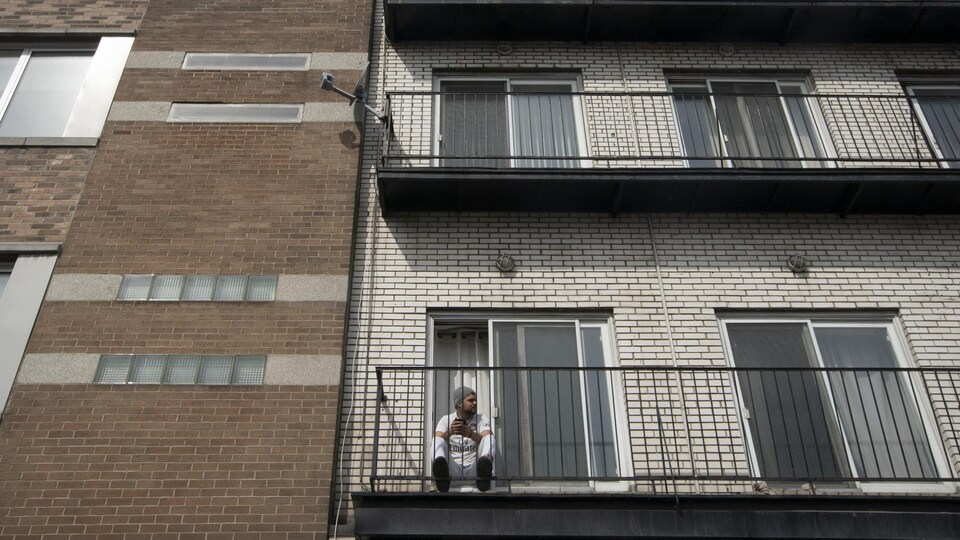 Un homme seul sur son balcon.