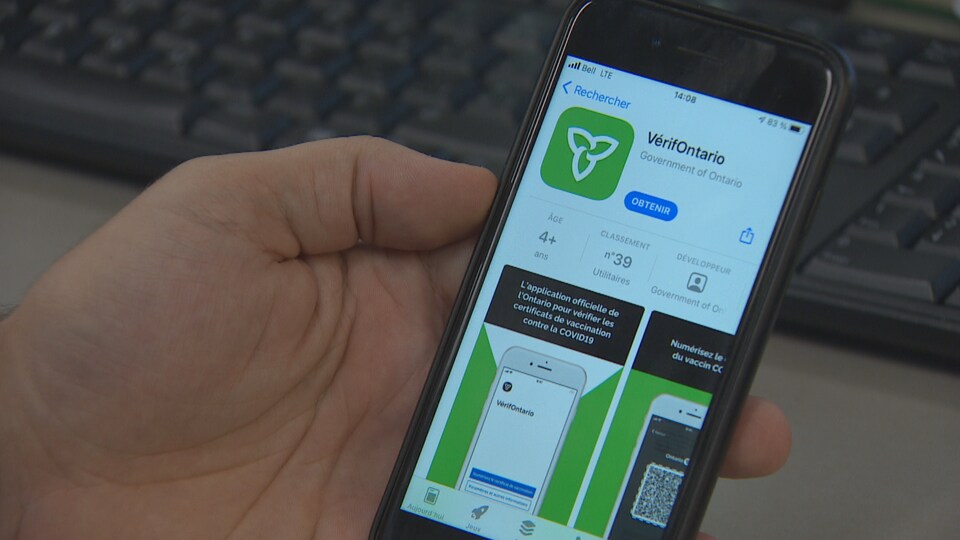 L'application est visible sur le téléphone d'une personne qui tient son cellulaire dans la main.