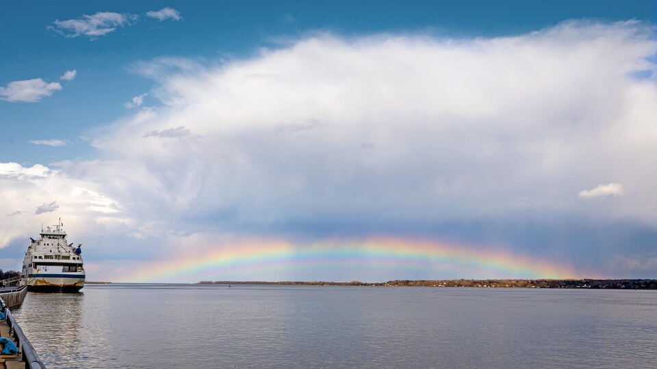 Un arc-en-ciel surplombe le fleuve.