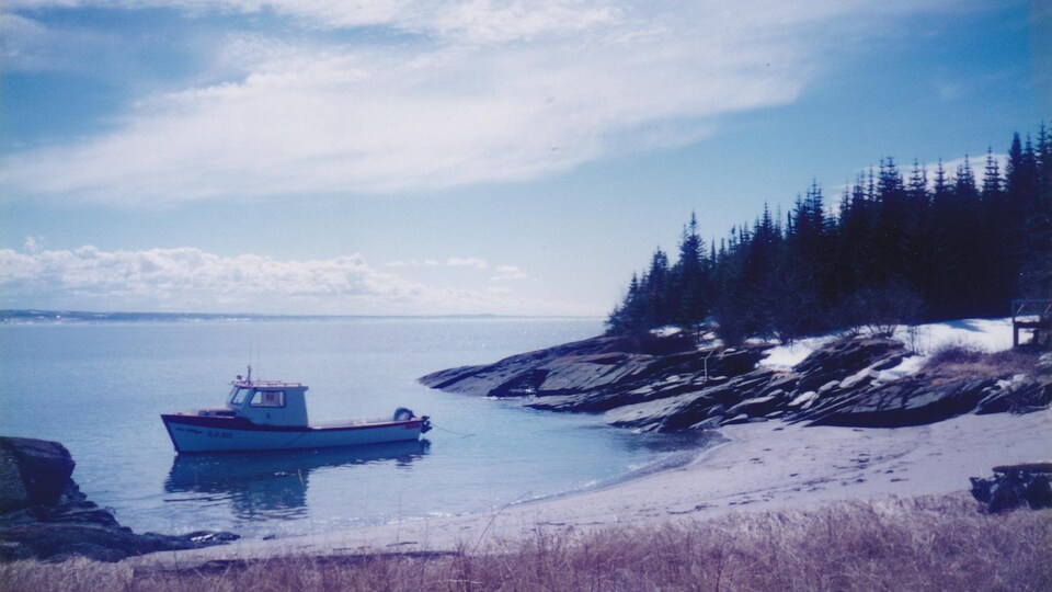 Le rivage et le bateau de traverse à l'Île aux Basques, au large de Trois-Pistoles.