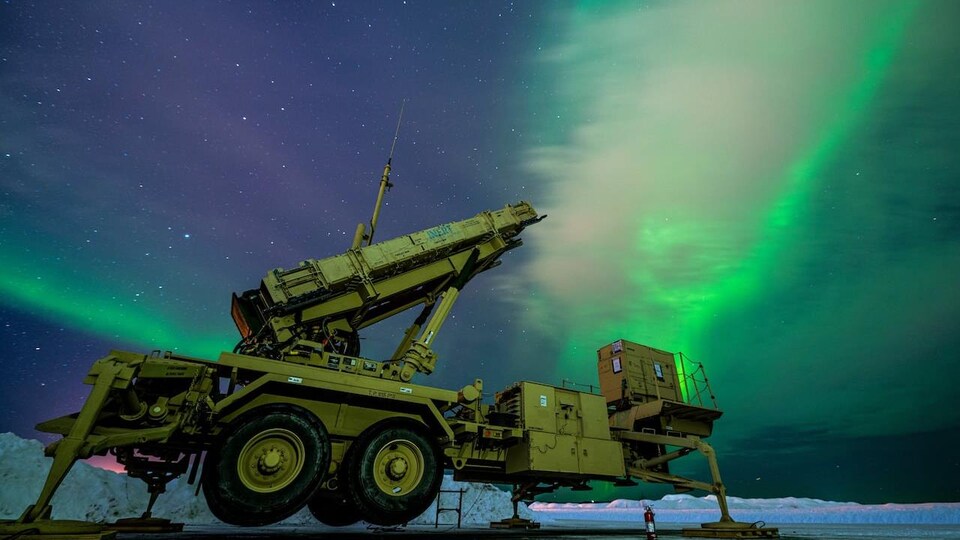 Un engin militaire sous une aurore boréale.