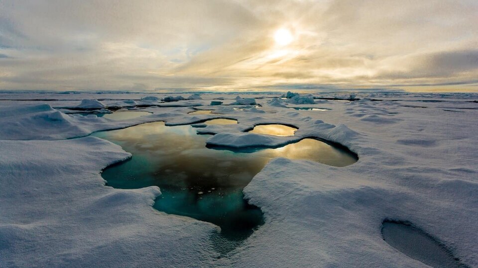 La couverture de glace de l'océan Actique partiellement fondue par endroits.
