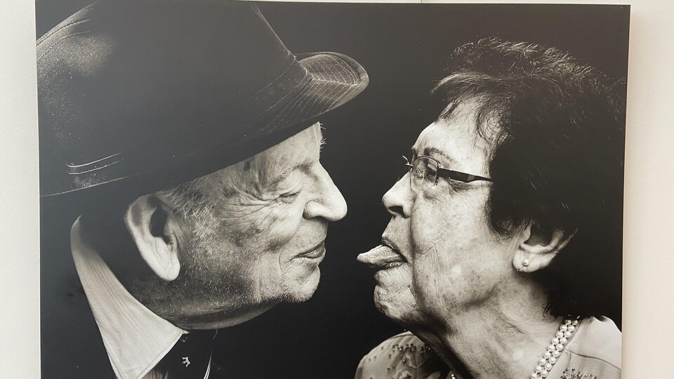 Une photo montrant une femme qui tire la langue à un homme qui la regarde avec affection. 