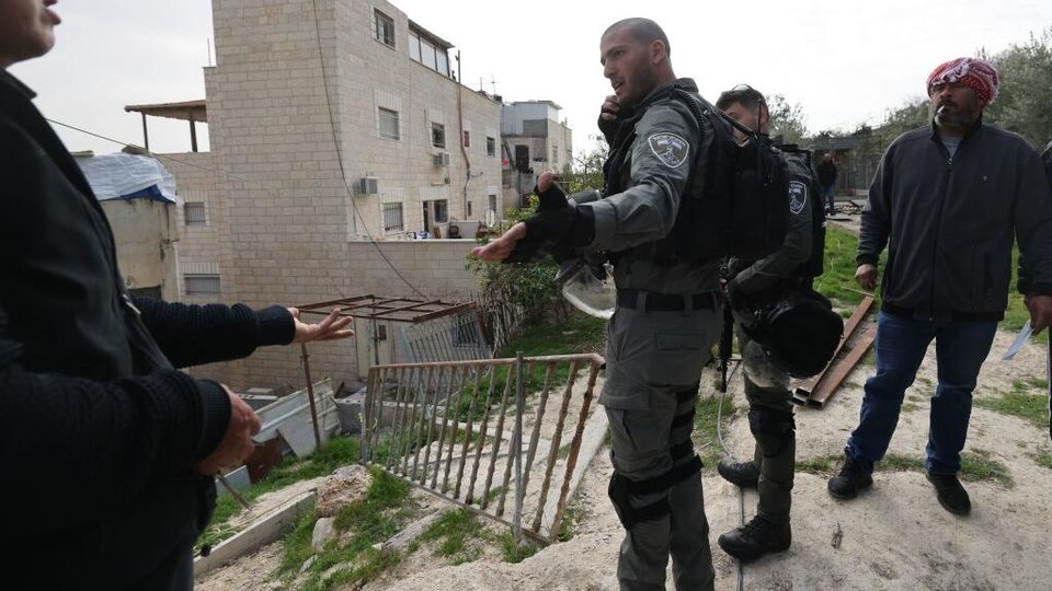 Des soldats israéliens discutent avec la famille de l'auteur d'une fusillade dans Jérusalem-Est.