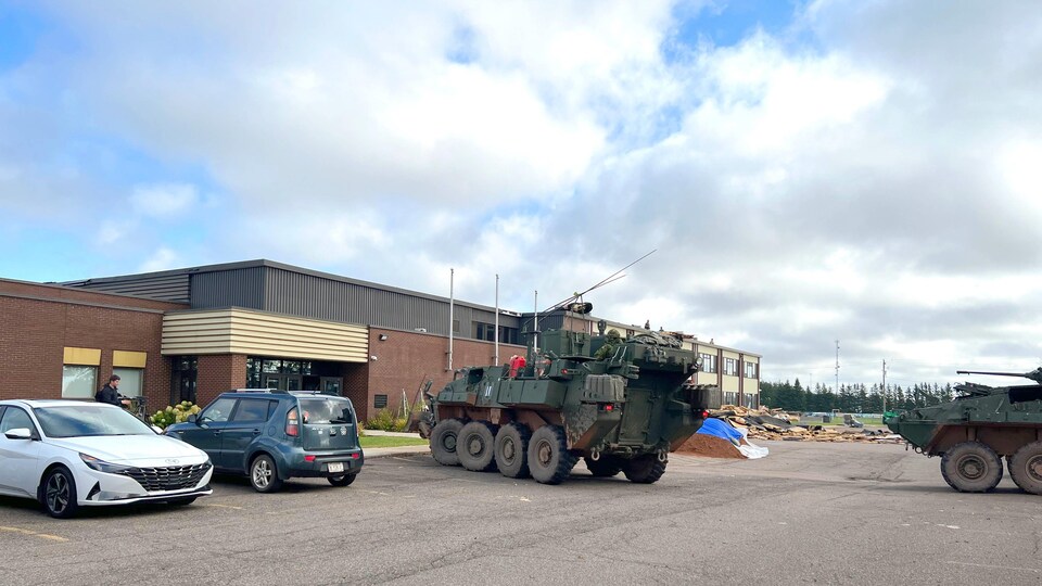 Des chars de l'armée canadienne dans le stationnement d'une école.