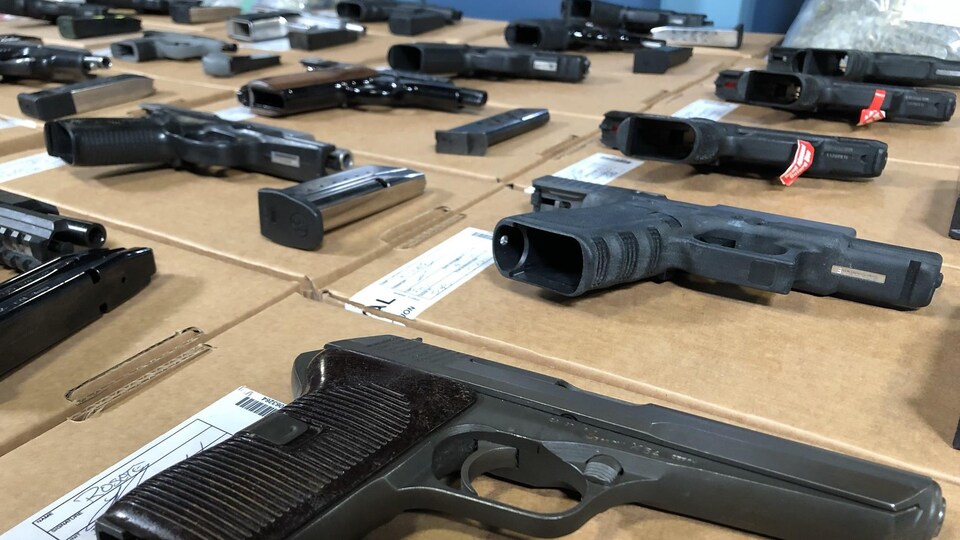Gros plan sur des armes de poing disposées sur une table