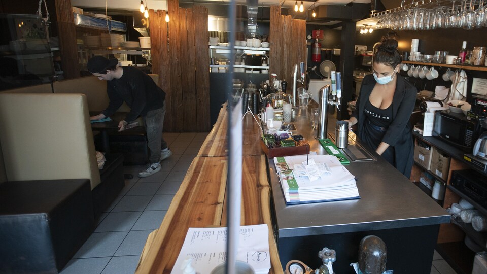 Deux employés sont à l'oeuvre dans un petit restaurant.