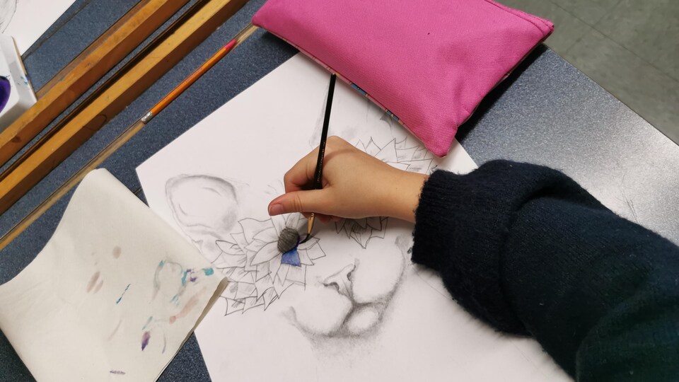 Une enfant dessine des fleurs.