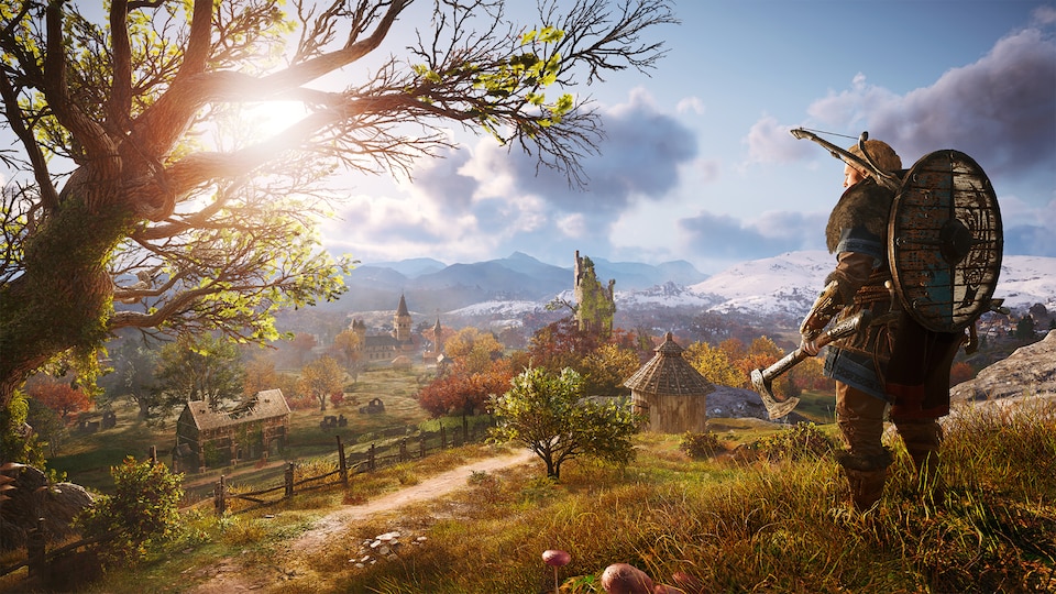 Capture d'écran d'un jeu vidéo montrant un guerrier viking en haut d'une montagne gazonnée, avec une vue sur un village. 