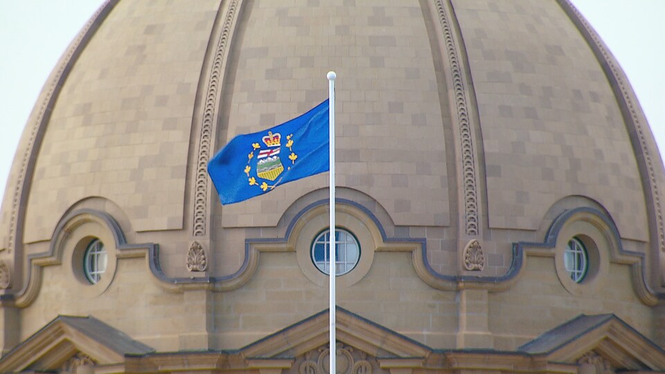 Le drapeau albertain flotte devant le dôme de l'assemblée albertaine à Edmonton