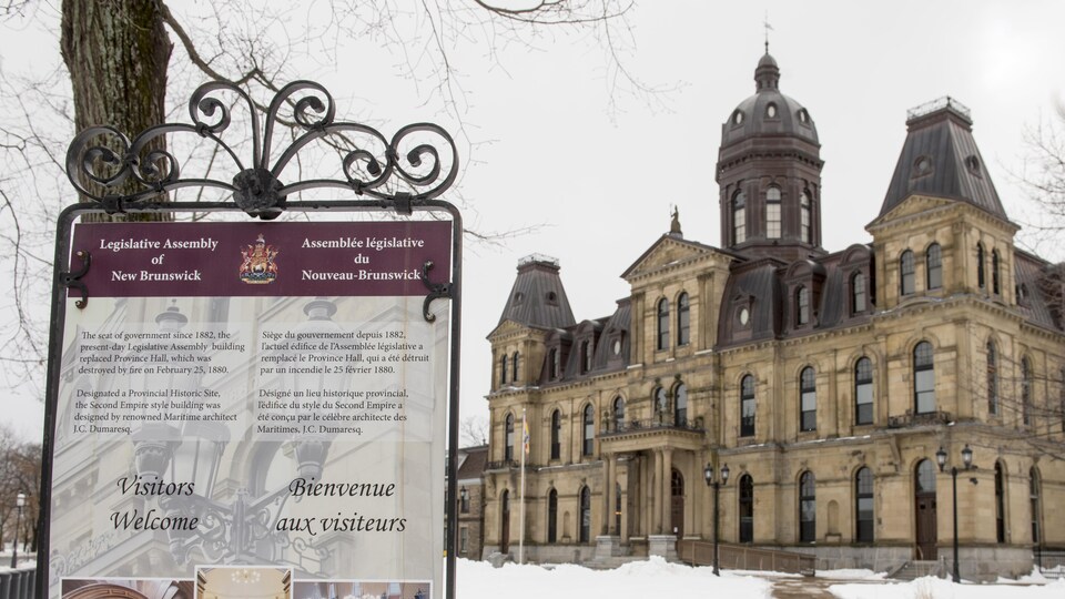 Édifice de l'Assemblée législative en hiver et l'enseigne devant l'édifice qui souhaite la bienvenue aux visiteurs.