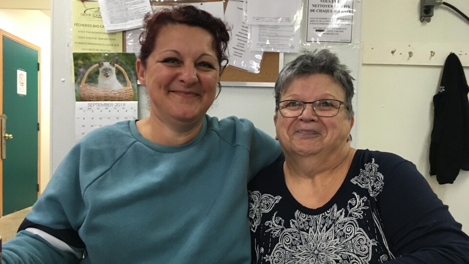 Deux femmes souriantes assises à une table.