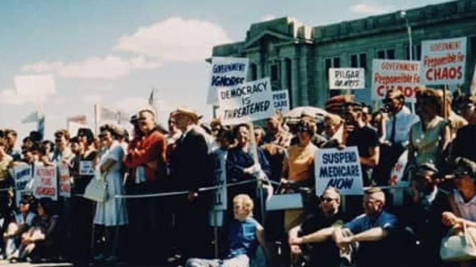 Des personnes avec des pancartes sur une photo d'archives.