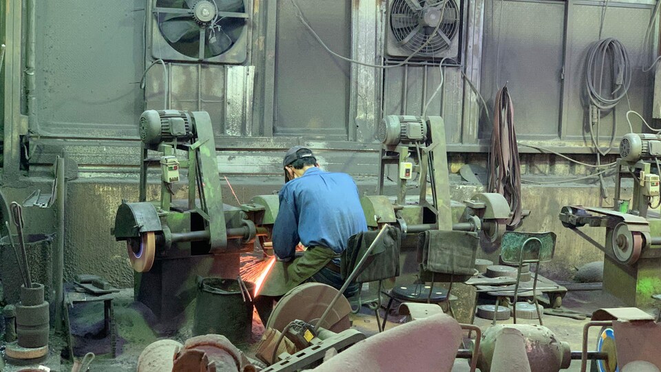 Un homme devant une machine dans un atelier.